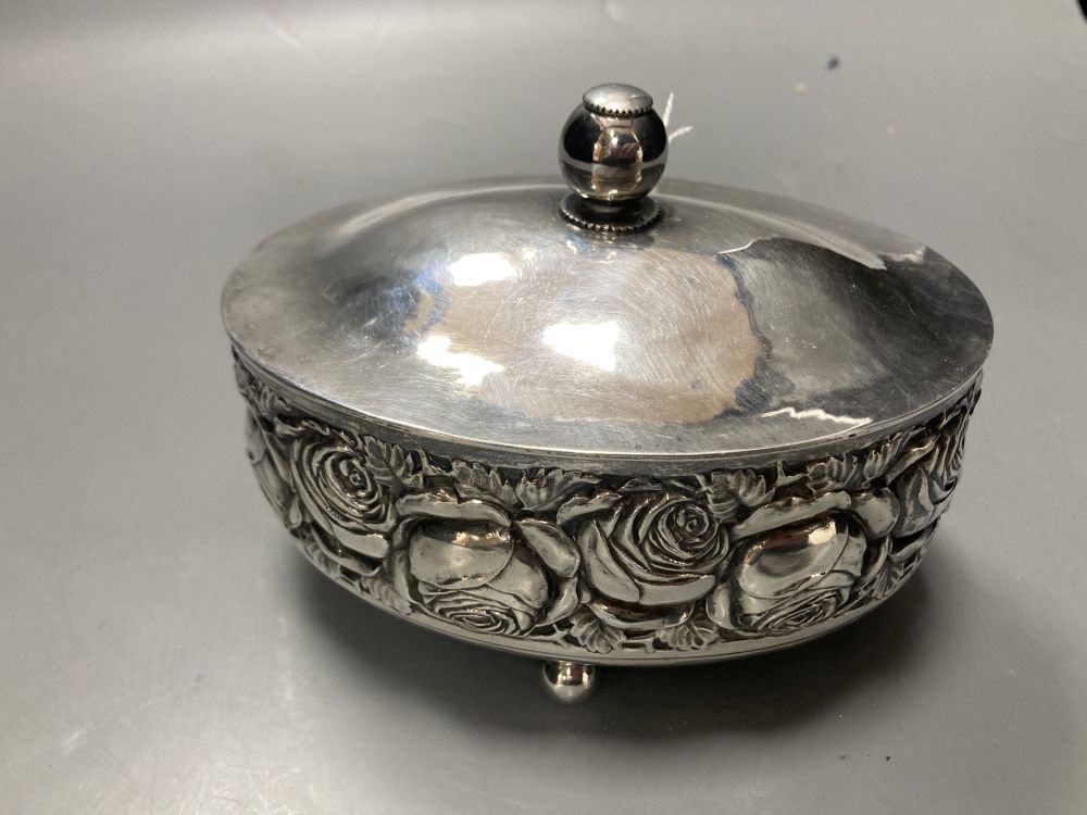 An early to mid 20th century continental 800 standard white metal oval lidded box, embossed with roses,